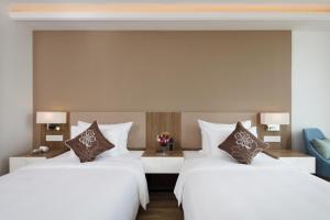 Postel nebo postele na pokoji v ubytování Comodo Nha Trang Hotel