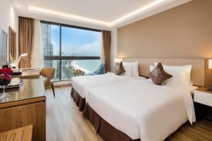 Postel nebo postele na pokoji v ubytování Comodo Nha Trang Hotel