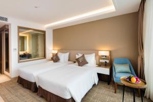 Postel nebo postele na pokoji v ubytování Comodo Nha Trang Hotel
