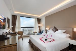 Postel nebo postele na pokoji v ubytování Comodo Nha Trang Hotel