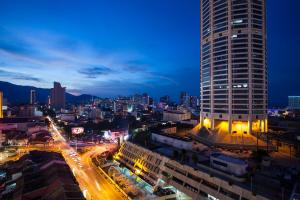 a city skyline with a tall building at night at The Granite Luxury Hotel Penang in George Town