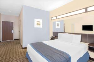 A bed or beds in a room at Microtel Inn and Suites San Angelo