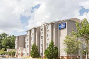 a building with a sign on the side of it at Microtel Inn & Suites by Wyndham Saraland in Saraland