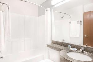 uma casa de banho com um lavatório, um chuveiro e uma banheira em Microtel Inn and Suites San Angelo em San Angelo