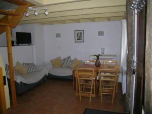 a living room with a table and chairs and a couch at Ti Gwen in Plonévez-du-Faou