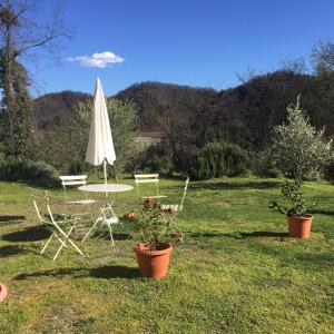 CaminoにあるCanonica dei Templariの芝生の上にテーブルと傘と椅子