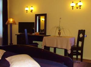 a living room with a table and a mirror at Iris Villa in Vatra Dornei