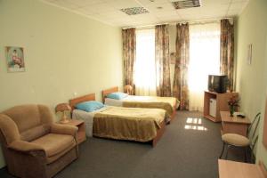 Cette chambre comprend deux lits, un canapé et une chaise. dans l'établissement Regina na Baumana, à Kazan