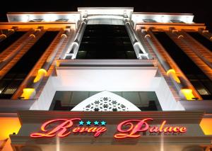 een frontaal uitzicht op een gebouw met een neonbord bij Revag Palace Hotel in Sivas