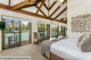 a bedroom with a bed and a balcony at The Terraces Main Beach in Byron Bay