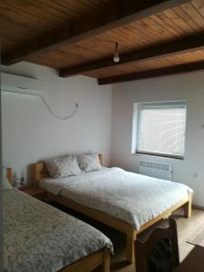 een slaapkamer met 2 bedden en een raam bij Apartment M&M in Pačir