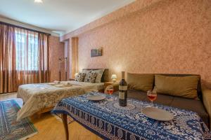 a living room with a couch and a table with wine glasses at Alpha Tbilisi in Tbilisi City