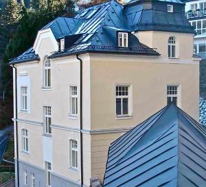 duży biały budynek z niebieskim dachem w obiekcie CasaNeve w mieście Bad Gastein