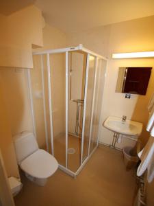 a bathroom with a shower and a toilet and a sink at Hotell Linnéa in Ljungby