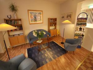 sala de estar con sofá, sillas y mesa en Hotell Linnéa, en Ljungby