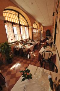 a restaurant with tables and chairs in a room at Hotel Miramare in Ladispoli