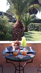 una mesa con comida en ella con una palmera en Chambres d'hôtes Villa Alizé, en Grimaud
