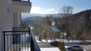 a balcony with a view of a snow covered mountain at Apartament Juzo in Szklarska Poręba