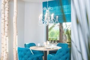 ein Esszimmer mit einem Tisch und blauen Stühlen in der Unterkunft Hotel-Restaurant Birkenhof in Bad Soden-Salmünster