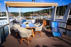 una terraza con mesa y sillas en un barco en Floating Sea House KAHNE Portorož en Portorož