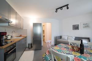 a kitchen and living room with a table and a refrigerator at Villa Alice App2 in Ližnjan