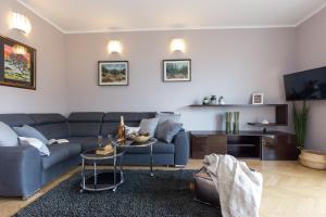a living room with a blue couch and a table at Apartmani Violic in Punat