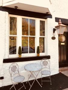 une table et deux chaises devant une fenêtre dans l'établissement Quadrant Cottage, à Buxton