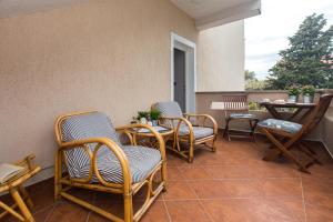 a porch with rocking chairs and a table and a table at Apartmani Violic in Punat