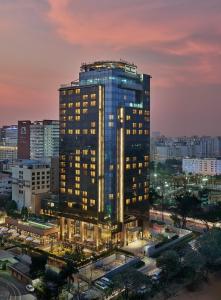 a tall building with lights on in a city at The Den, Bengaluru in Bangalore