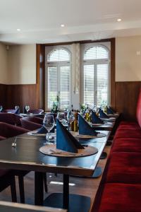 Hotel Taverna في Tafers: صف من الطاولات في غرفة بها نوافذ