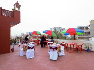 a group of tables and chairs with umbrellas on a roof at Taj Haveli Hotel Agra - Walkable Distance From Taj Mahal in Agra