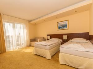 Un pat sau paturi într-o cameră la Król Plaza Spa & Wellness
