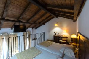 - une chambre avec un lit et une télévision murale dans l'établissement Al Castello Resort, à Sillavengo