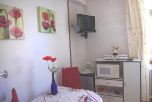 une chambre avec une table, un four micro-ondes et un vase avec une fleur dans l'établissement Gîte Meyer-Liss, à Ribeauvillé