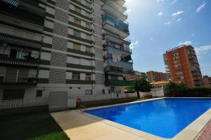 a swimming pool in front of a tall building at La Torre Orange Costa in Benicàssim