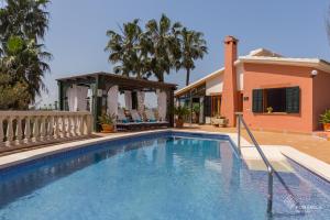 a swimming pool in front of a house at Finca Can Marti in Alcudia
