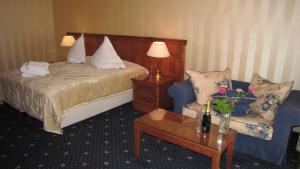 a hotel room with a bed and a couch and a table at Vila Codrin Neptun-Olimp in Neptun +7 photos