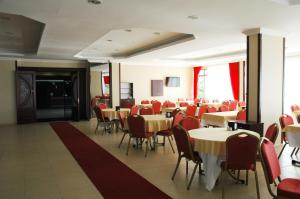 une salle à manger avec des tables, des chaises et des chaises rouges dans l'établissement Burgaz Resort Aquapark Hotel, à Kırklareli