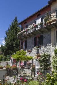 an old stone building with flower boxes and balconies at Bed and Breakfast Papillon in Perledo