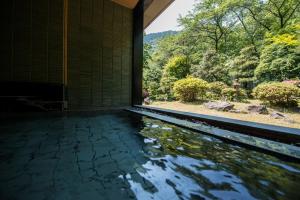 een zwembad met water in een kamer met uitzicht bij Takamiya Bettei Kuon in Tsuruoka