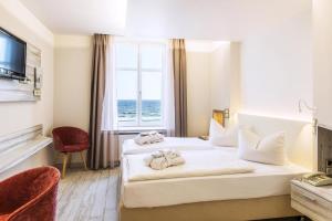 Postel nebo postele na pokoji v ubytování SEETELHOTEL Strandhotel Atlantic das Boutiquehotel am Meer