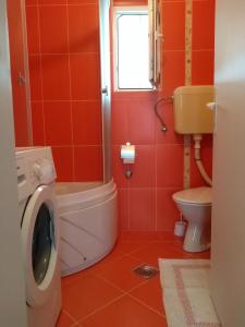 a bathroom with a washing machine and a toilet at Apartman Otvoreno polje in Arandelovac