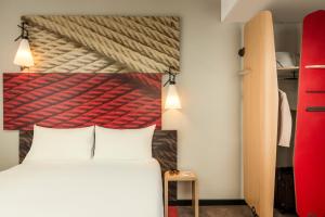 a bedroom with a bed and a red painting on the wall at ibis Bordeaux Centre - Gare Saint-Jean in Bordeaux