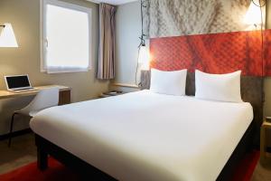 a hotel room with a large bed and a desk at ibis Bordeaux Centre - Gare Saint-Jean in Bordeaux