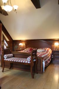 a bedroom with a large wooden bed with a bench at Apartment 1925 in Palanga