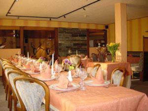 une longue table avec des nappes et des chaises roses dans l'établissement Hotel Saint-Hubert, à Malmedy
