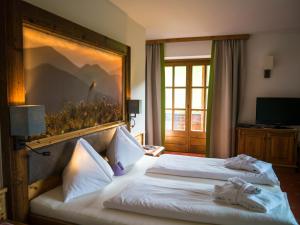 A bed or beds in a room at Familienhotel Gasthof Hinteregger