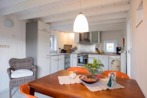 - une cuisine avec une table en bois et des chaises orange dans l'établissement Bellevue Maison de Greunebennet, à Plombières