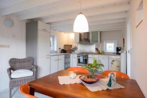 una cocina con mesa de madera y sillas naranjas en Bellevue Maison de Greunebennet, en Plombières