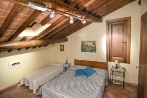 two beds in a room with wooden ceilings at Villa Il Palazzo in Cortona +44 photos